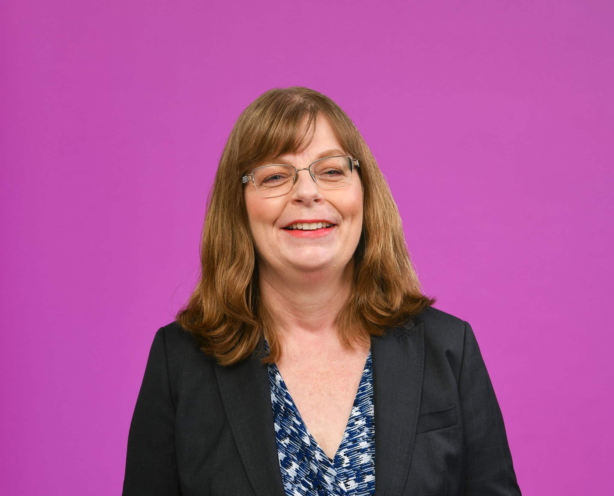 Portrait of Dr Debbie Nisbet against a purple background